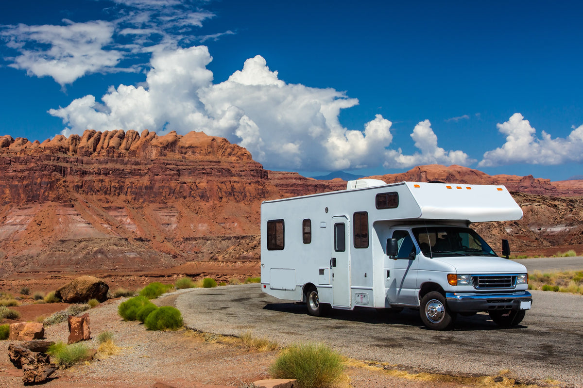 white RV parked on road by the Grand Canyon