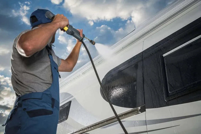 a man pressure washing an RV