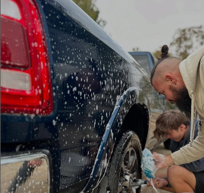 two men washing a truck with poli glow